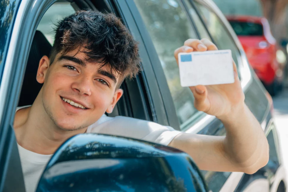 Führerschein bestanden. Junger Mann zeigt seinen erhaltenen Führerschein.